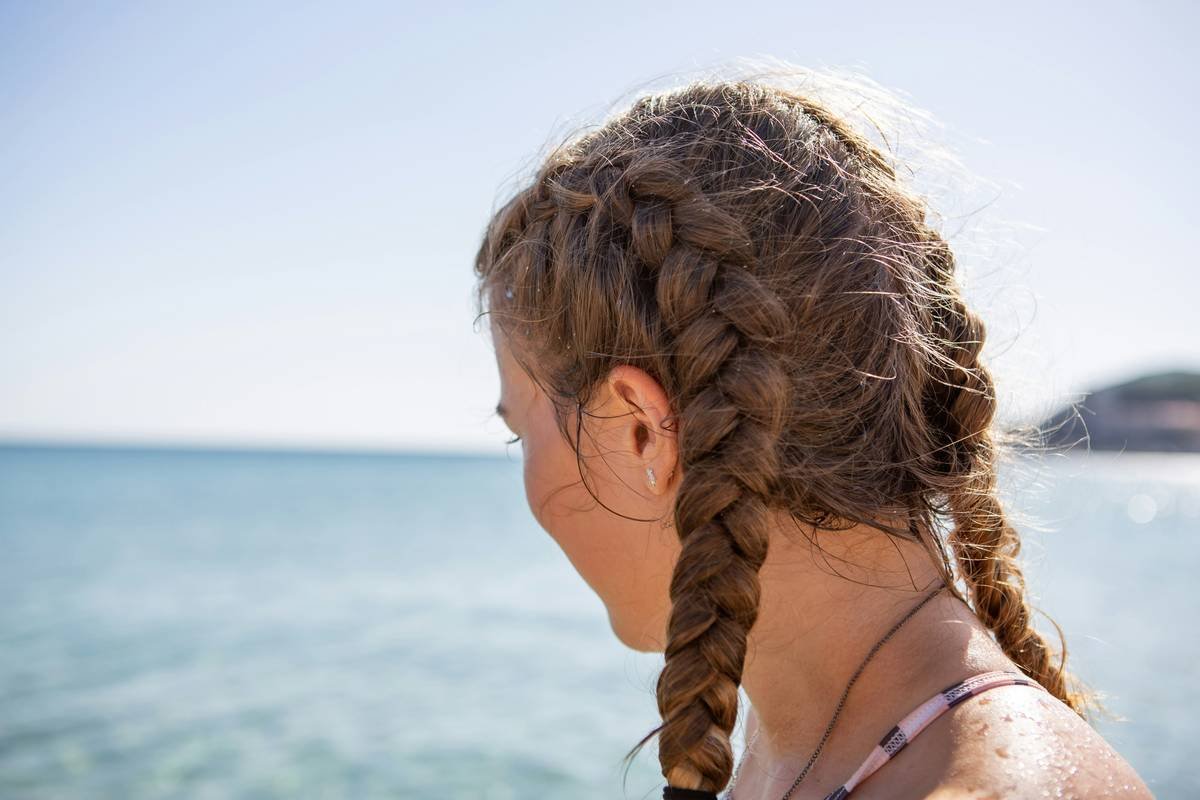 Infographic showing how UV rays degrade hair keratin, strip color pigments, and cause cuticle lifting